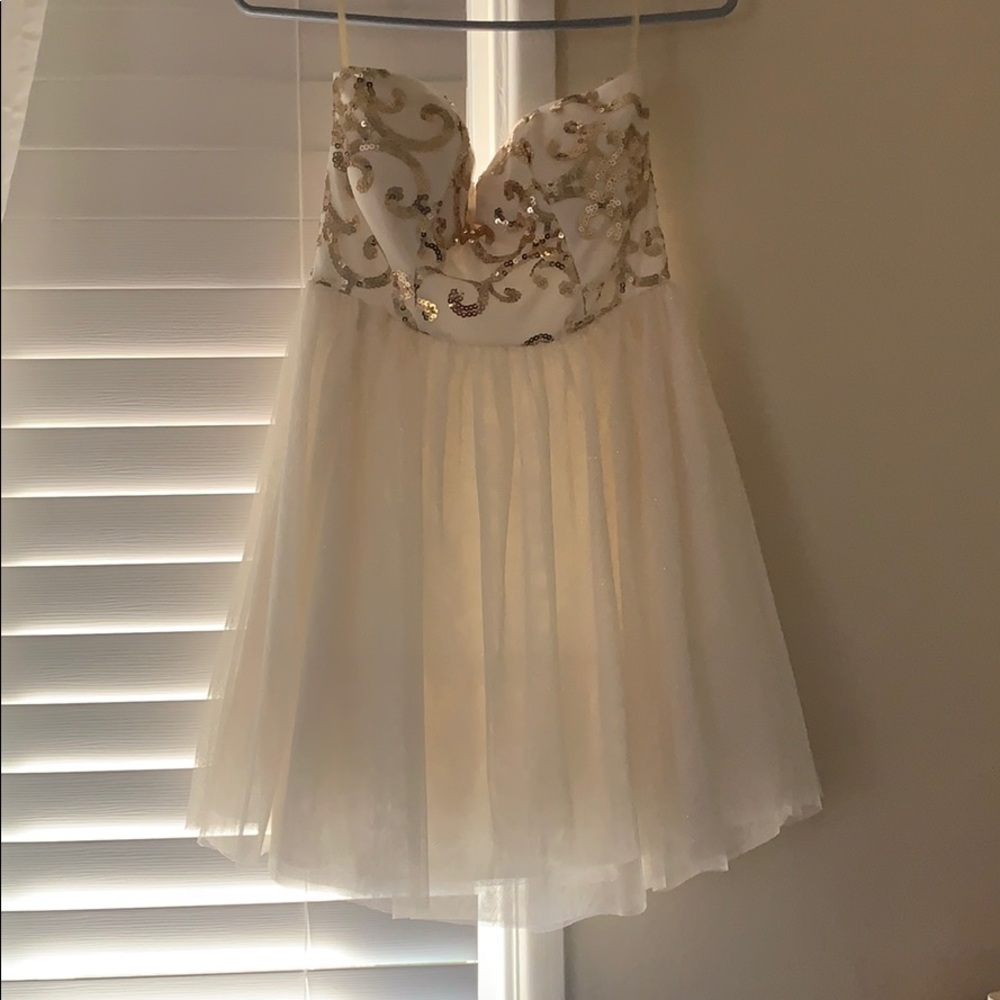 Short sequenced and glittery cream and gold dress.